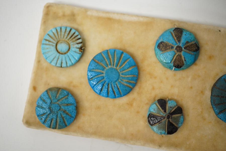 Antiquities - a group of eight blue glazed composition rosettes/buttons, used for garment decoration, 1000B.C - 600 B.C., largest 22mm. Condition - good for age and use